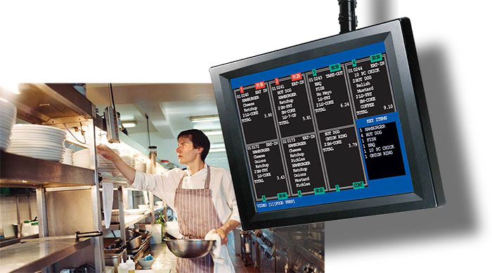 A kitchen display screen showing a live order list, mounted in a working kitchen