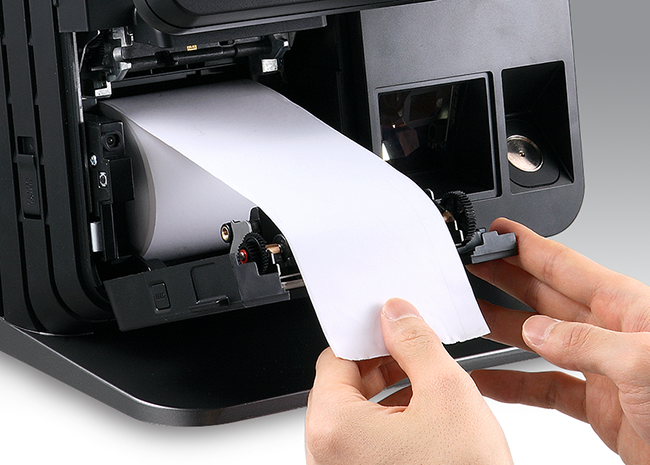 Hands loading a receipt roll into the built-in printer of an EPOS terminal